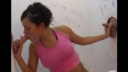 Sitzt auf der Toilette und macht einen Blowjob durch ein Loch