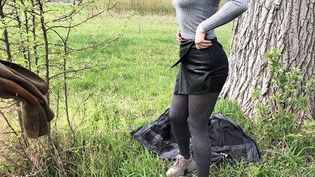 Ein Mädchen in sexy Ledershorts bläst im Freien einen Schwanz und schluckt das Sperma