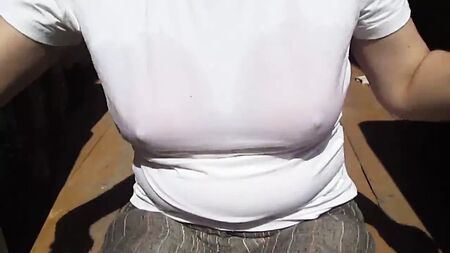 Ein Mädchen zieht ihren nassen Bade-BH unter ihrem nassen T-Shirt aus