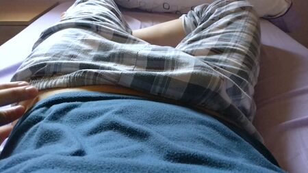 Ein süßer Twink-Junge lockt damit, seinen Schwanz unter seiner karierten Pyjamahose zu zeigen