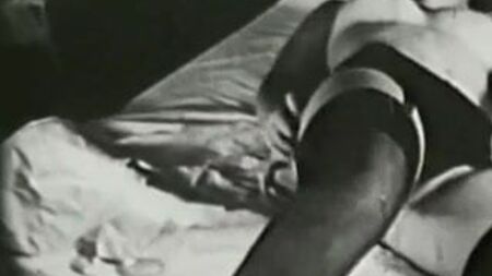 Mädchen im Bett mit sexy schwarzen Strümpfen (Vintage aus den 1960er Jahren)