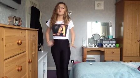 Ein sexy Mädchen probiert enge, glänzende Spandex-Leggings an