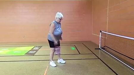 Reife Frau ohne BH mit riesigen, hängenden Brüsten beim Pickleballspielen