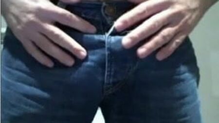 Behaarter Jungspund spielt in blauen Jeans an seinem Schwanz herum