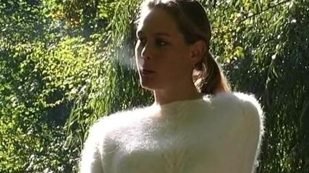 Eine Frau in einem flauschigen Pullover raucht