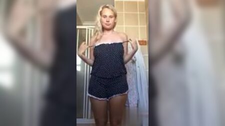 Blondine mit großen Brüsten zieht sich in ihrem Badezimmer aus