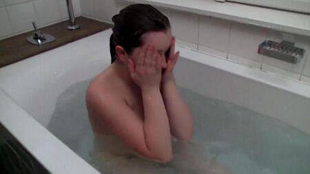 Die Dame masturbiert einen Schlauch aus einer Dusche in einem Bad