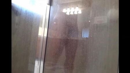 Die versteckte Kamera schießt, während ein Mann unter der Dusche wäscht