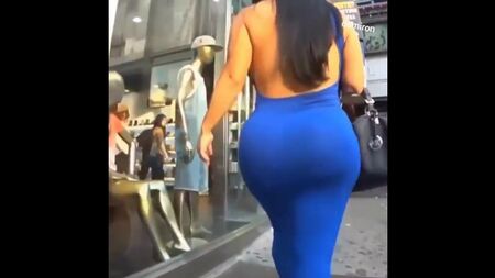 Eine Frau mit großem Hintern, die die Straße entlanggeht